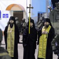 Orthodox priests stand with armed men, thought to be Russian troops, blocking a Ukrainian frontier guard base in Balaklava, near the Crimean port of Sevastopol, on Saturday. Moscow keeps ex-Soviet states firmly in line