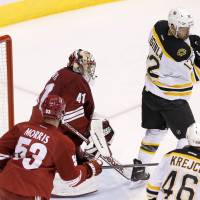Trick shot: Boston’s Jarome Iginla redirects the puck past Phoenix goalie Mike Smith in the third period on Saturday night. The Bruins beat the Coyotes 4-2. Bruins wax Coyotes for 12th straight victory