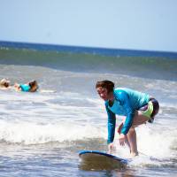 First-time surfer Donna Lawlor of New York successfully navigates the waves at Playa Guiones in Nosara. Costa Rica beach offers sustainable tourism