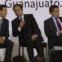 Forging strong ties: Mexican President Enrique Pena Nieto, left, speaks with Honda CEO Takanobu Ito, center, as Ildefonso Guajardo, Mexico’s economy minister, checks paperwork at the opening ceremony for Honda Motor Co.’s new plant in Celaya, Mexico, on Feb. 21. Auto boom fuels Japanese culture mix in Mexico