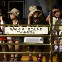 Safety in numbers: Japanese tourists sit on the Waikiki Trolley in Honolulu. Group tours shield travelers to a degree from the reality of being a foreigner abroad, an experience that might otherwise help them empathize with outsiders in their home country. Tackling the 'empathy deficit' toward non-Japanese