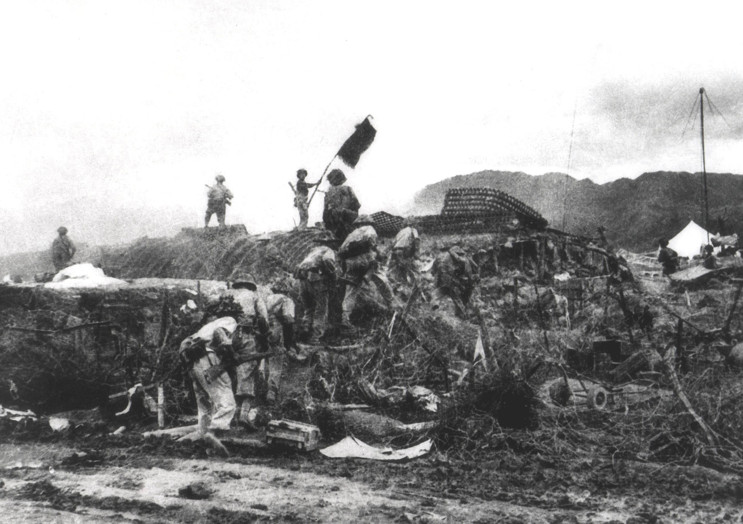 A Vietnamese soldier waves a flag atop a French command post during the Dien Bien Phu war | The Japan Times