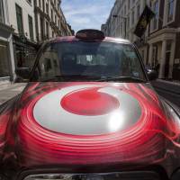 A Vodafone ad covers the hood of a London taxi last September. A report from the cellphone firm says government surveillance of phone networks is common worldwide. Vodafone reveals shocking scale of government snooping