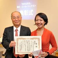 First steps: At an event in January 2013, former Tokyo Immigration Bureau chief Hidenori Sakanaka presents Indonesian Dewi Rachmawati with a prize for an essay she wrote about her struggle to become a nurse in Japan. Japan's 'no immigration principle' looking as solid as ever