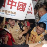 Supporters and protesters of China's Zhang Zhijun, minister of the Taiwan Affairs Office, fight upon his arrival at the airport in Taoyuan county, Taiwan, on Wednesday. China sent Zhang, its first ever ministerial-level official to Taiwan for four days of meetings to rebuild ties with the self-ruled island Beijing claims as its own, but he canceled and fled earlier than planned due to the protests. Chinese official cancels events in Taiwan amid violent protests