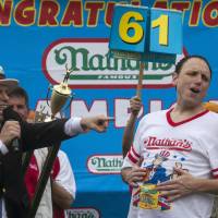Men’s division winner Joey Chestnut celebrates after winning the annual Nathan’s Famous Fourth of July Hot Dog Eating Contest on Coney Island in New York on Friday. Chestnut keeps hot dog title, wins fiancee
