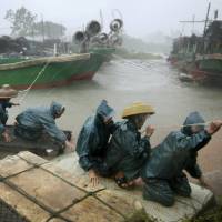 Fishermen are transported to a safer area amid strong wind and heavy rainfall at a port as Typhoon Rammasun hits Zhanjiang, Guangdong province Friday. Super Typhoon Rammasun, strongest in 40 years, hits southern China