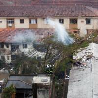 Rescuers work on the site of the crash of the Cessna 560XL jet carrying the presidential candidate of the Brazilian Socialist Party, Eduardo Campos, in Santos, Sao Paulo state, on Wednesday. The plane crashed into a gymnasium and two homes and several people died in the accident, including all its occupants. Brazil presidential candidate Campos reported dead in plane crash