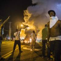 Police fire tear gas near Ferguson, Missouri, in an attempt to disperse protesters as violent unrest continued Monday in reaction to the shooting of an unarmed local black teenager, Michael Brown. In riot-hit Ferguson, traffic fines boost tension and budget