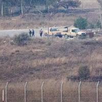 A picture taken from the Israeli-occupied Golan Heights shows armed men, reportedly rebel fighters, standing near vehicles in the Syrian side, near the Quneitra border crossing, on Thursday. Israel closed off the area around Quneitra the previous day after an officer was wounded by stray fire as Syrian rebels seized control of the crossing. 43 Golan peacekeepers seized by Syria militants, 81 trapped, U.N. says