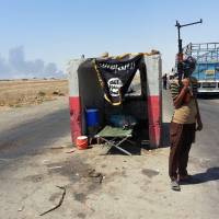 An militant from the group now known as the Islamic State stands guard at a checkpoint captured from the Iraqi Army outside Beiji refinery, some 250 km (155 miles) north of Baghdad, in June. As Islamic militants rampaged across northern Iraq in June, seizing vast swaths of territory and driving hundreds of thousands of people from their homes, the Shiite Turkmens living in the hardscrabble town of Amirli decided to stay and fight. Against all odds, Iraqi town holds out against militant onslaught
