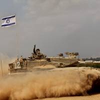 An Israeli soldier flashes the V-sign for “Victory” on board his Merkava tank near the border between Israel and the Gaza Strip while returning from the Hamas-controlled Palestinian coastal enclave on Tuesday, after Israel announced that all of its troops had withdrawn from Gaza. Israel completed the withdrawal as a 72-hour humanitarian truce went into effect following intense global pressure to end the bloody conflict. Israel withdraws troops, 72-hour Gaza truce begins