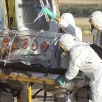 Aid workers and doctors on Aug. 7 transfer Miguel Pajares, a Spanish priest who was infected with the Ebola virus while working in Liberia, from a plane to an ambulance as he leaves the Torrejon de Ardoz military airbase near Madrid. A spokeswoman for a Madrid hospital says the missionary priest, who received the experimental U.S. drug ZMapp, died Monday. Spanish priest dies of Ebola amid ethics debate over experimental drug