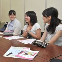 Megumi Sumi (left) of the nonprofit organization Hanalabs speaks with female university students working on a project to help revitalize local communities. Nonprofit group aims to help female students meet their potential
