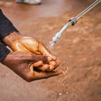 A health worker in the Sierra Leone capital of Freetown sprays the hands of a man with chlorinated water as part of an Ebola prevention campaign held on Wednesday. U.S. experts eye Japanese drug in race for Ebola cure