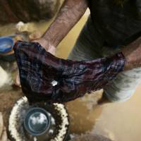 An artisanal miner shows mercury used for processing gold puddled in a handkerchief in El Corpus, Honduras, in July 2008. Corporate blowback builds from Minamata treaty