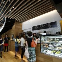Customers order food and drinks at a counter in the Rakuten Cafe in Tokyo on May 29. Companies across the nation are revamping their offerings as the government attempts to boost female participation in the workforce. Firms revamp menus to tap fruit of Abe's 'womenomics' pledge