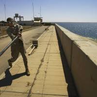 U.S. Marine Lance Cpl. Andrew Bickerstaff of Satellite Beach, Florida, uses a tent pole in 2005 to bat a rock off the Haditha Dam, where his unit is based, 220 km northwest of Baghdad. The U.S. military launched airstrikes Sunday around the dam in western Iraq, targeting Islamic State insurgents there for the first time in a move to prevent the group from capturing the vital dam. Obama to outline strategy as U.S. expands airstrikes against Islamic State in Iraq