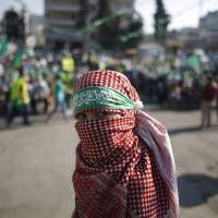A masked Palestinian boy takes part in a rally celebrating what organizers say was a victory by Palestinians in Gaza over Israel following a ceasefire, in the West Bank city of Ramallah on Saturday. Israel plans big West Bank land grab around Bethlehem