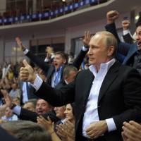 Russian President Vladimir Putin (foreground) gestures as he attends the Judo World Cup in the city of Chelyabinsk in Siberia, Russia, on Sunday. Putin is calling on Ukraine to immediately start talks on a political solution to the crisis in eastern Ukraine, including discussing statehood. Putin calls for talks on east Ukraine 'statehood'; rebels fire on ship
