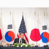 Prime Minister Shinzo Abe, U.S. President Barack Obama and South Korean President Park Geun-hye are seen during a meeting in the Hague in late March. A series of behind-the-scenes diplomatic efforts by all three sides in recent months have increased Abe’s chances of long-awaited summits with Park and Chinese President Xi Jinping. Economic benefits have China, South Korea reconsidering strained ties with Japan