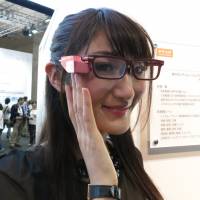 A model shows off a prototype of Toshiba Glass, the company’s new entry into the wearable tech market, at CEATEC 2014. Toshiba Glass sets sights on less obtrusive wearable tech