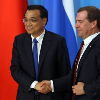 Russian Prime Minister Dmitry Medvedev and visiting Chinese Prime Minister Li Keqiang (left) prepare to attend a final news conference after their talks in Moscow on Monday. Russia and China plan to sign more than 40 very important bilateral documents after the 19th regular meeting of the two prime ministers in Moscow, Medvedev said. China, Russia seek 'international justice,' agree on currency swap line