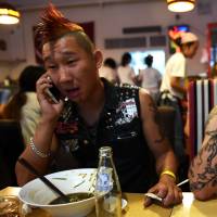 A marigold and magenta mohawk adorning his shaven skull, Chinese lead singer and self-proclaimed subversive punk rocker Shan Lin (left) and guitarist Wang Shaowu of Beijing punk band The Demonstrators tuck into some dinner before their performance at the annual Beijing Punk Festival on Aug. 30. In a country that suppresses dissent, Shan describes himself as a rebel with a cause. Anarchy in the People's Republic of China, according to Chinese punks