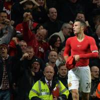 Strip tease: Manchester United's Robin van Persie salutes the crowd after equalizing against Chelsea in Sunday's 1-1 draw. Van Gaal slams 'stupid' Van Persie for booking