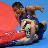 Tangled up: Shinya Matsumoto (right) competes against South Korea's Kim Gwan-uk in the men's freestyle 86-kg wrestling competition at the Asian Games on Wednesday. Japan misses out on Greco-Roman gold