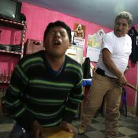 A teenager grimaces in pain as he is lashed by a “rondero,” a member of a citizen vigilante group known as a “rondas urbanas,” or urban patrol, in Cajamarca, Peru, in June.. In Peru, whip-cracking vigilantes serve up justice