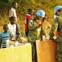 Self-Defense Forces personnel work among civilians seeking refuge last December in a compound run by the United Nations on the southwestern outskirts of Juba, the capital of South Sudan. U.N. logistics expert fears humanitarian disaster in South Sudan