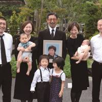Family affairs: A still from “Umareru Zutto Issho,” showing Kenzo Kon (center) holding a picture of his deceased wife, surrounded by his daughters, sons in law and grandchildren.© IndigoFilms, Inc. The birth of a new kind of personal documentarian