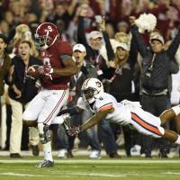 Can’t catch me: Alabama wide receiver Amari Cooper catches a touchdown pass in the third quarter ahead of Auburn’s Jonathon Mincy on Saturday. Alabama triumphs in wild Iron Bowl