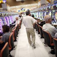Feeling lucky: Visitors play the machines at a pachinko parlor west of Tokyo. While you can win or lose a lot of money on such machines, the government does not consider them to be a form of gambling. Is happiness worth the risk of addiction?