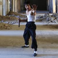 Abbas Alizada, who calls himself the Afghan Bruce Lee, poses for the media in Kabul on Tuesday. From the ruins of an iconic bombed-out palace above Kabul, the young man bearing a striking resemblance to the kung fu legend is high-kicking his way to Internet fame, aiming to show another side to his war-weary nation. 'Afghan Bruce Lee' high-kicking his way to Internet fame