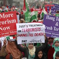 Supporters of political party Pakistan Awami Tehreek (PAT) hold signs to condemn last week's attack by Taliban gunmen on the Army Public School in Peshawar, during a Sunday rally in Lahore. Pakistan makes arrests in Taliban school massacre