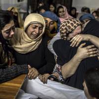 Women mourn for a 15-year-old relative who was killed in an attack by Pakistani Taliban gunmen on an army school Tuesday in Peshawar. Pakistani pupils recall narrow escapes, carnage in Taliban slaughter at Peshawar school