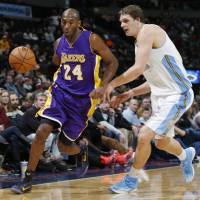 Black Mamba: Lakers star Kobe Bryant dribbles past Nuggets center Timofey Mozgov on Wednesday in Denver. Kobe sparks Lakers to win