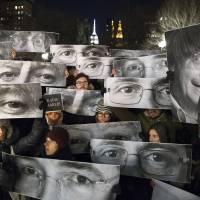 Mourners hold signs depicting victim's eyes during a Thursday morning rally in support of Charlie Hebdo at a vigil in Union Square in New York. 'Je Suis Charlie' goes viral: Mass rallies held for French massacre victims