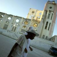 Haitians pass in front of the ruins of the old Cathedral of Port-au-Prince on Monday, the fifth anniversary of the devastating earthquake that hit Haiti. The 2010 temblor killed 300,000 people. Haiti remembers quake dead amid political crisis