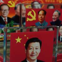 Decorative plaques featuring Chinese leaders of past and present, including current President Xi Jinping (front), are seen at a souvenir stall in Beijing in October. Fear and retribution rule amid Xi's crackdown on corruption in China