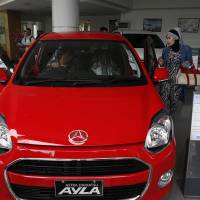 A customer inspects a Daihatsu Ayla car at a showroom in Jakarta on Nov. 11. Daihatsu dismantling 'Toyota Way' as market changes