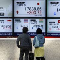 Watching the future: Pedestrians in Tokyo look at the stock market indices of various countries over the New Year's holiday. What's worth getting excited about in 2015?