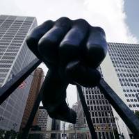 City icon: The Detroit skyline rises behind a monument to renowned boxer Joe Louis, also known as The Fist. Bankrupt Detroit on the way to recovery