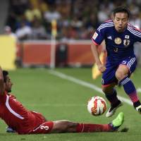 Hurdle cleared: Yuto Nagatomo leaps over a challenge from Jordan's Tareq Khattab during Japan's 2-0 win at the Asian Cup in Melbourne, Australia, on Tuesday. Japan gathering steam as Asian Cup gets down to business