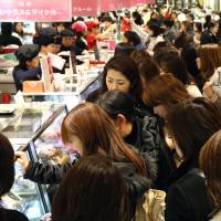Chocolate counters at an Isetan department store in Tokyo are packed on Feb. 7, ahead of Valentine's Day. Heart-shaped madness as women splurge for Valentine's Day