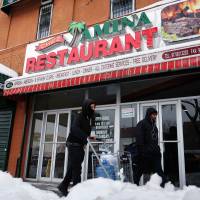 Two men walk past the Chez Amina restaurant in New York's borough of the Bronx on Tuesday. Nafissatou Diallo recently opened the restaurant, two years after she settled her civil case against French economist, lawyer and politician Dominique Strauss-Kahn for an undisclosed amount. Strauss-Kahn, 65, whose high-flying career imploded when he was accused of sexually assaulting Diallo, a New York hotel maid in 2011, is back in court over his role at the center of a prostitution ring. DSK sex scandal maid now New York restaurant owner