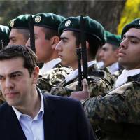 Greek Prime Minister Alexis Tsipras reviews an honor guard at the Presidential Palace during a welcoming ceremony ahead of a meeting with Cypriot President Nicos Anastasiades in Nicosia on Monday. Greece ruptures 30 years of political consensus in Europe