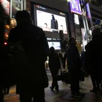 A giant TV in Tokyo shows a purported Islamic State video in which the two Japanese hostages were threatened with death. Abe, hostages labeled troublemakers in conformist Japan